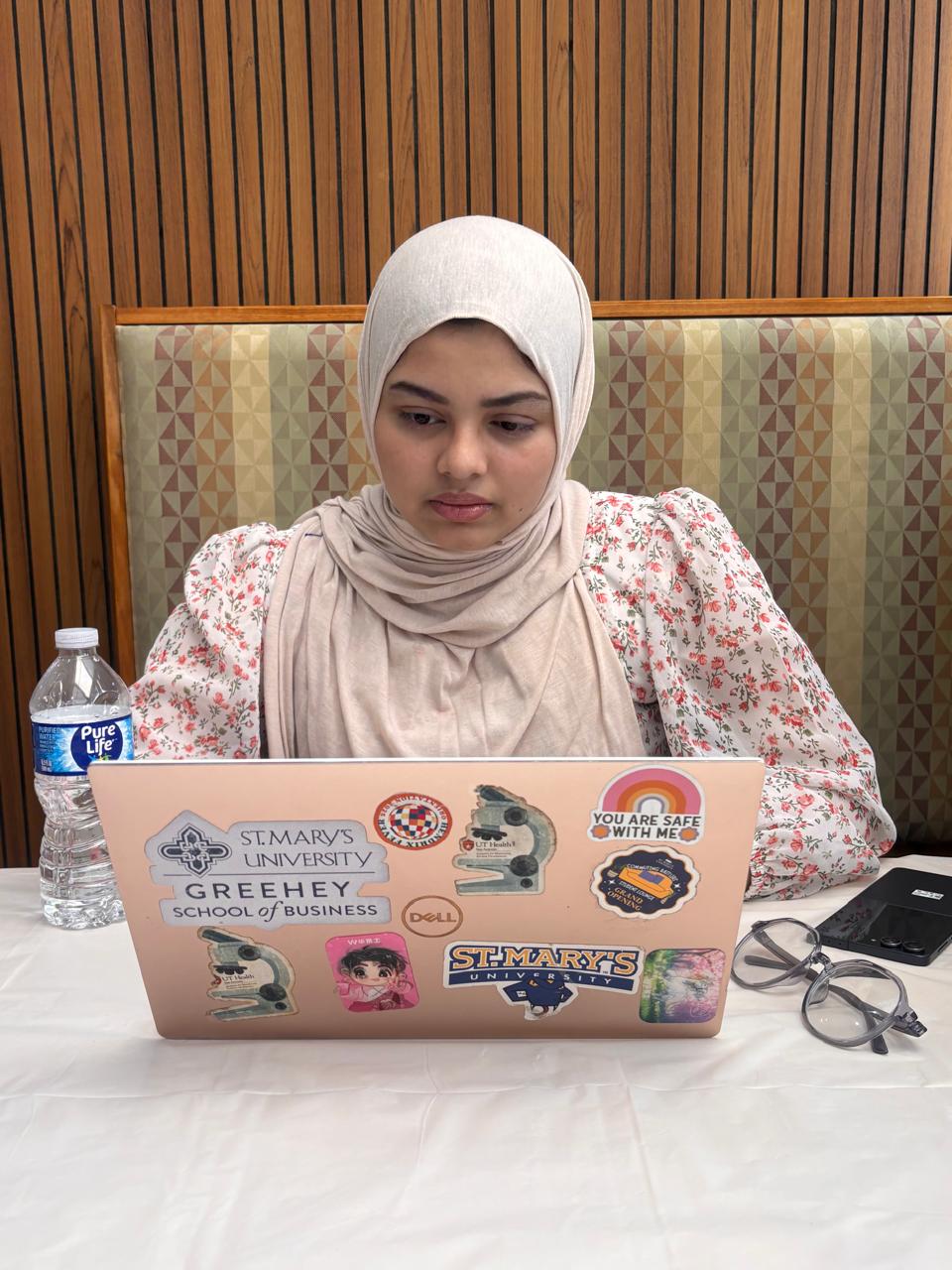 The researcher works at a laptop at a table