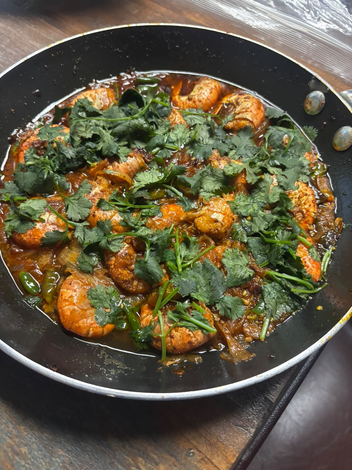 A pan of shrimp curry topped with fresh cilantro