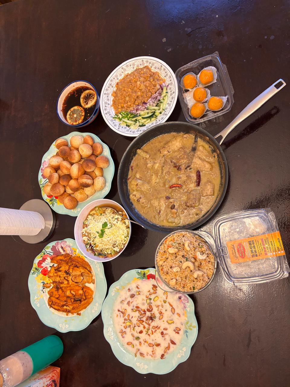An overhead view of several Bengali dishes and sweets arranged on a table